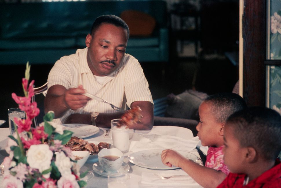 Martin Luther King Jr. serves pieces of chicken to his young sons Marty and Dexter at Sunday dinner on November 8, 1964.